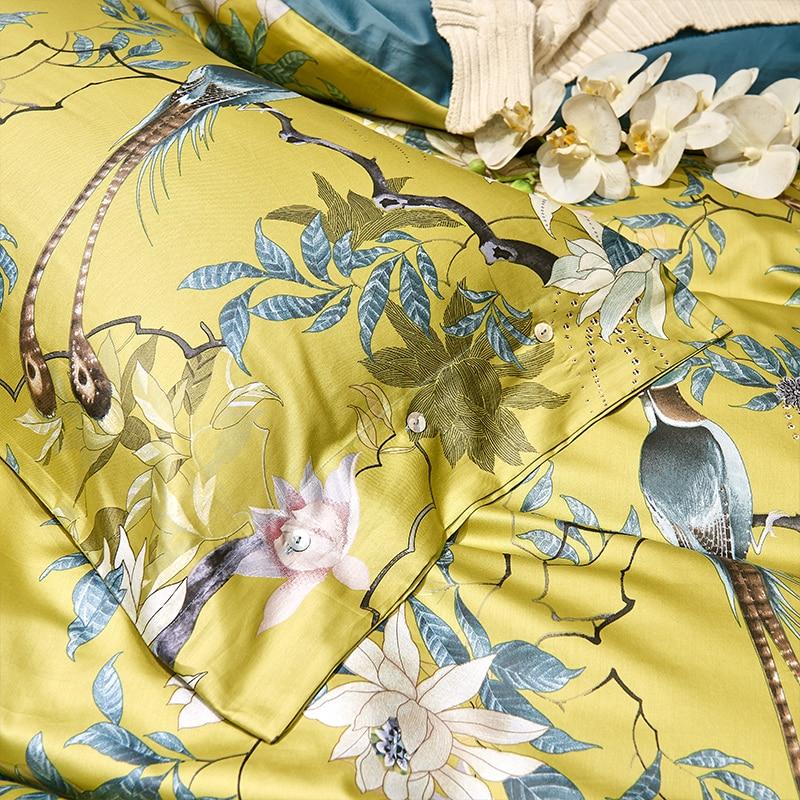 Yellow birds printed queen king duvet cover set made of Egyptian Cotton with pillow covers in a bedroom with a bedside table lamp on a wooden floor.