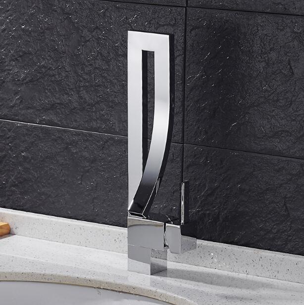 Elegant Black Bathroom Faucet Martina on a White Marble Sink with black wall.