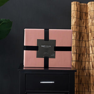 Pink Venetia Duvet Cover Set on a black bedside table.
