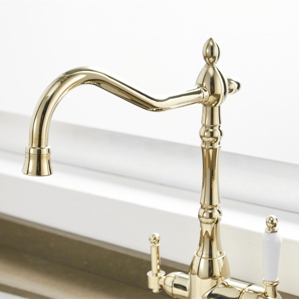 Isaac kitchen faucet in gold color with white dual white handles with beautiful water stream.