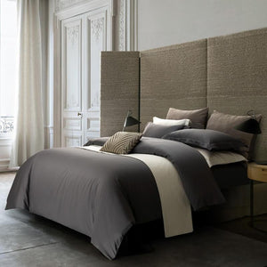 Beautiful full egyptian cotton duvet cover set in a white room with wooden bedside lamp.