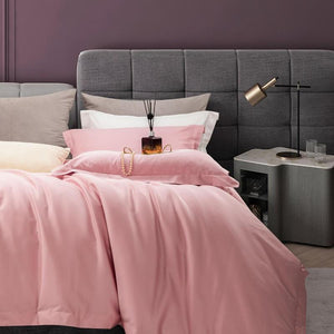 Pink Egyptian Cotton comforter with a bedside table and two glasses with a lamp.