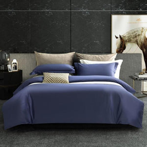 Blue Juan Egyptian Cotton Duvet Cover Set with white bed sheets and one black bedside table and one marble bedside table with magazines and  horse picture in the back.