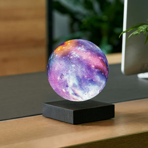 Floating galaxy lamp by Gingko on a walnut color desk.