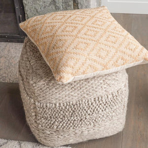 Handwoven Textured Taupe Pouf in a living room, on top you can see one of our handwoven throw pillows.