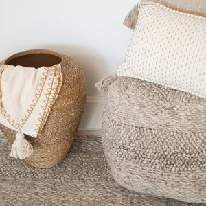 Handwoven Textured Taupe Pouf in a living room with on Anaya's rug.