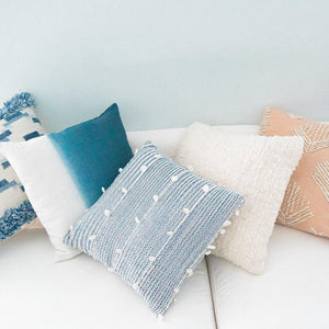 Variety of Anaya's throw pillows on a white sofa from Home And Tower.