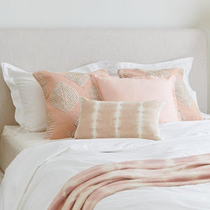 Pink Geometric Leaf Embroidered Throw Pillow on a bed dress with a white bedding set.