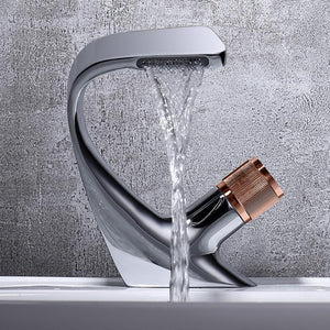 close up of single rounded brass handle chrome bathroom faucet with soft water flow.