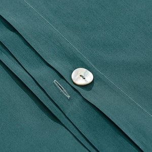 Close up of button of the green bed sheets made of Egyptian cotton. 