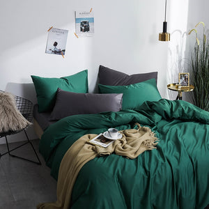 Grace Silk Green Duvet Cover Set in minimalist bedroom. The bedding set comes with two pillowcases, the duvet cover, and the flat bed sheet.