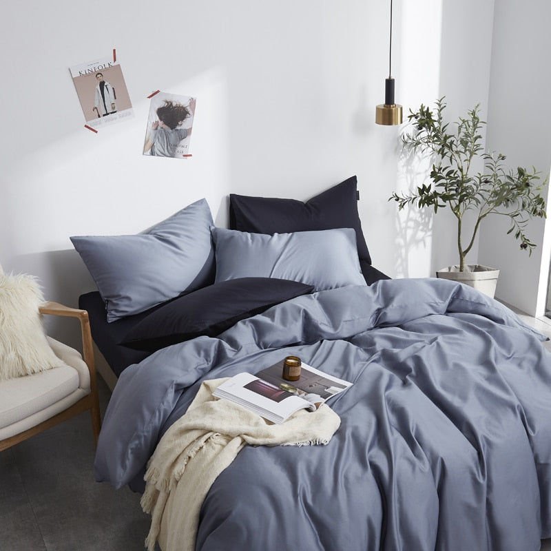Front view of Florentine Silk Blue Duvet Cover Set in minimalist bedroom. The bedding set comes with two pillowcases, the duvet cover, and the flat bed sheet.