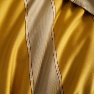 Close up of ochre color bed sheets.