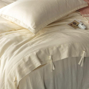 Cream color linen and cotton bedding sheets with ropes.