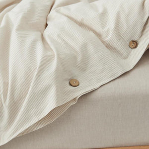 Cream color bed sheets with buttons.
