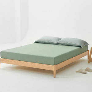 Fitted bed sheets on a wooden bed with two pillow covers.