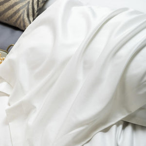 Close up of white bedding sheets.