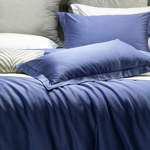 close up of blue pillow covers and blue bed sheets.